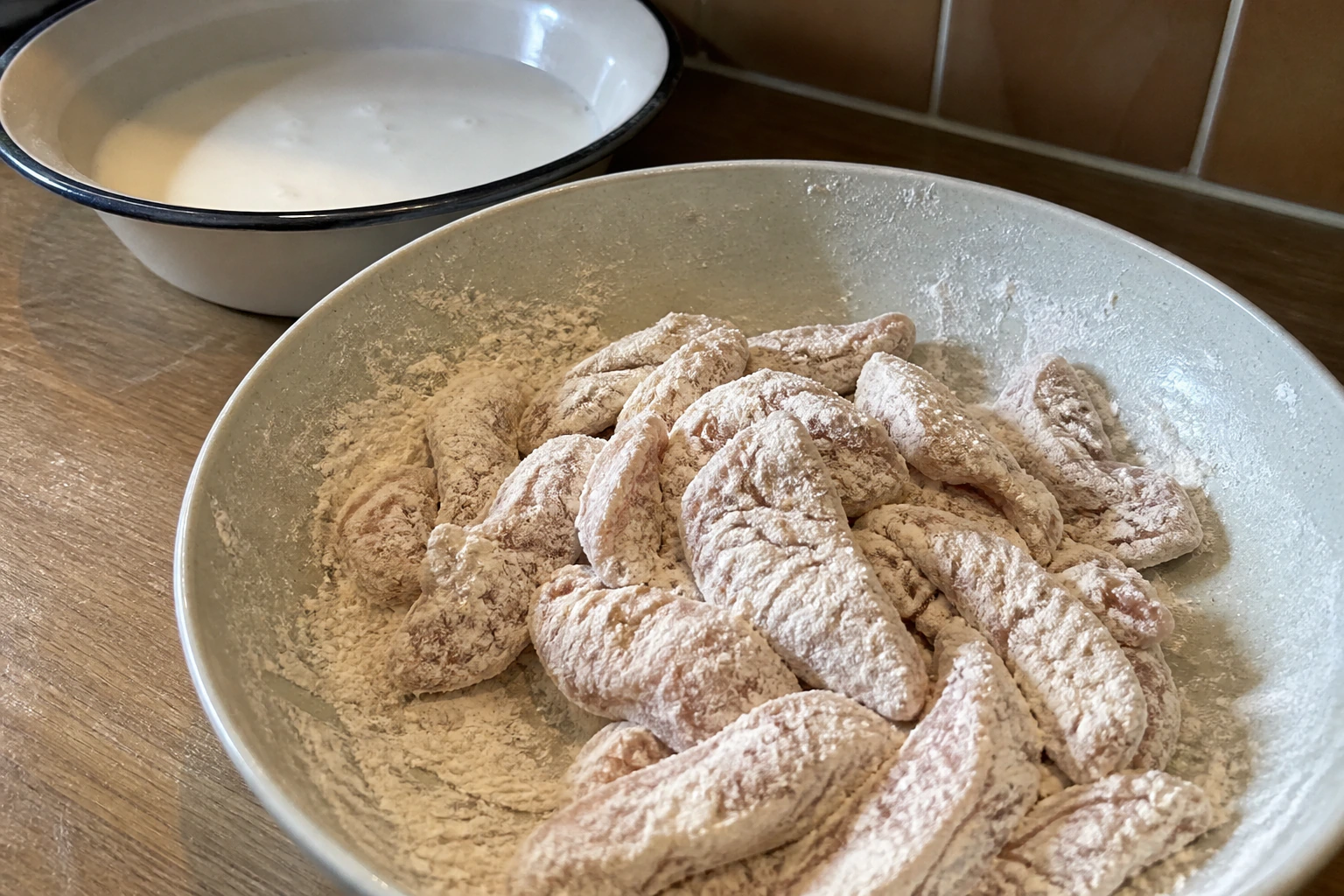 Seasoned flour with small craggy buttermilk clumps being rubbed together in a kitchen bowl