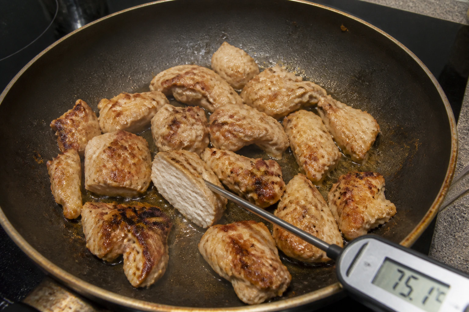 Irregular browned gyros chicken with one cut piece and a probe checking the thickest centre