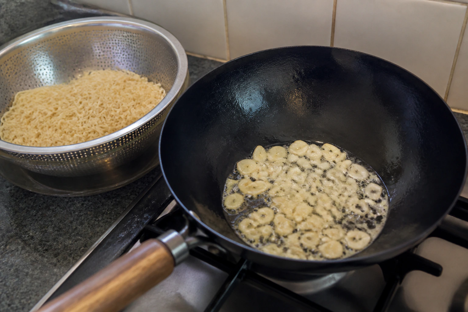 Finely chopped garlic gently sizzling in oil while still pale in a home kitchen wok