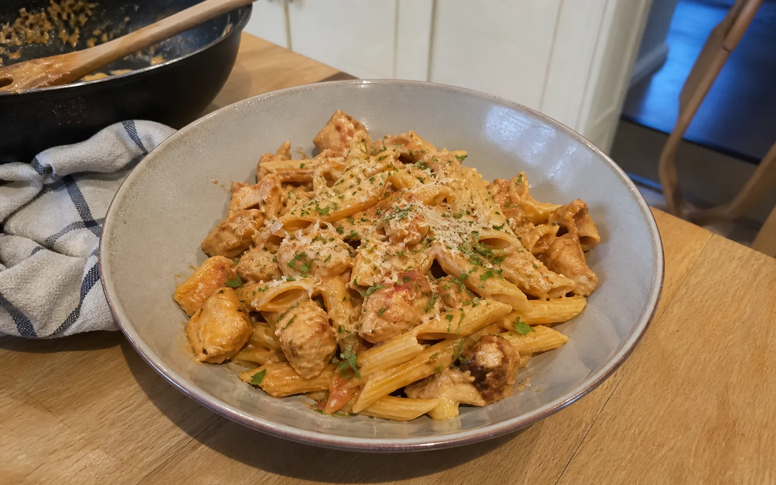 Homemade creamy chicken pasta in a tomato cream sauce on a kitchen table