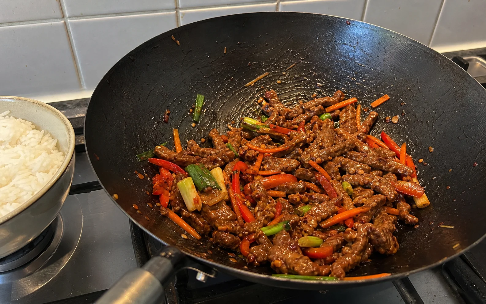 Crispy chilli beef with pepper, carrot and spring onion freshly tossed in a wok