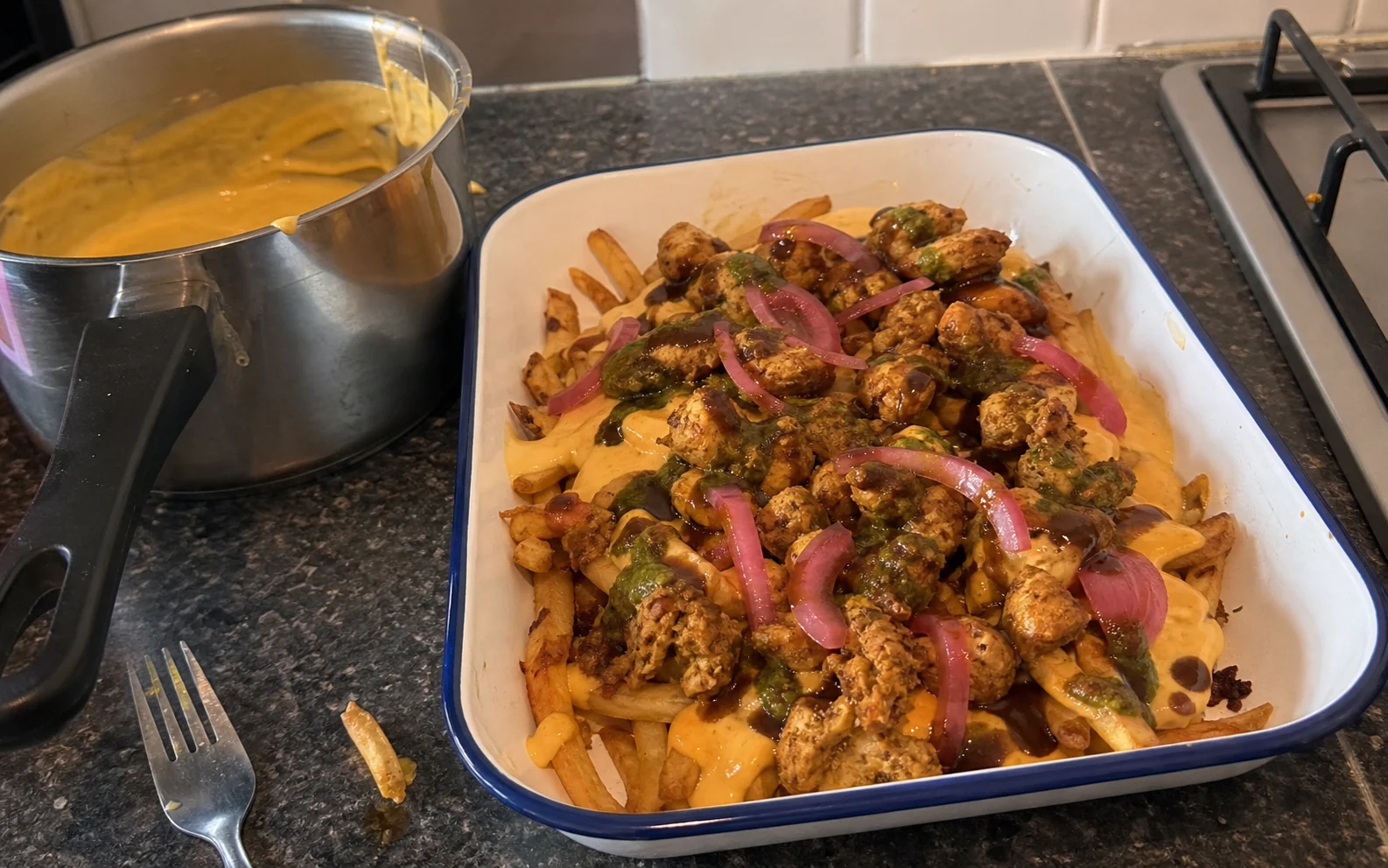Loaded masala fries with spiced chicken, cheese sauce, pickled onion and chutneys