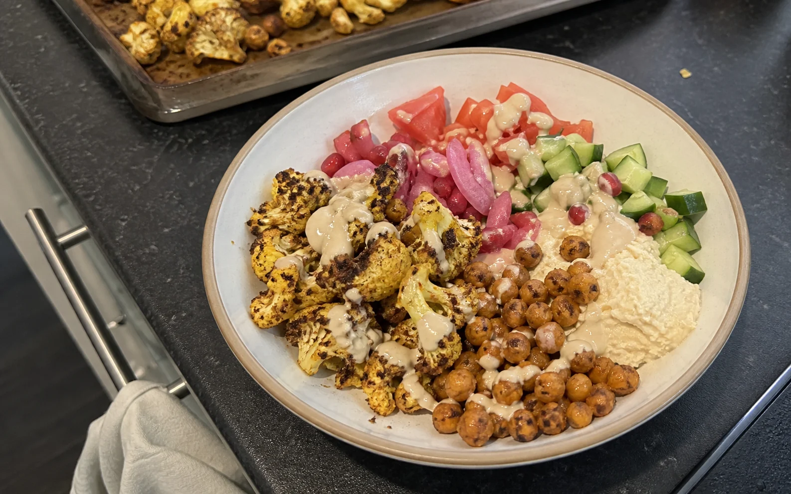 Roasted cauliflower bowl with crisp chickpeas, hummus, vegetables and tahini dressing