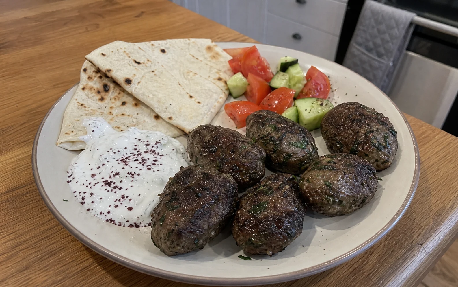 Turkish-inspired lamb kofta with flatbread, garlic yoghurt, tomato and cucumber