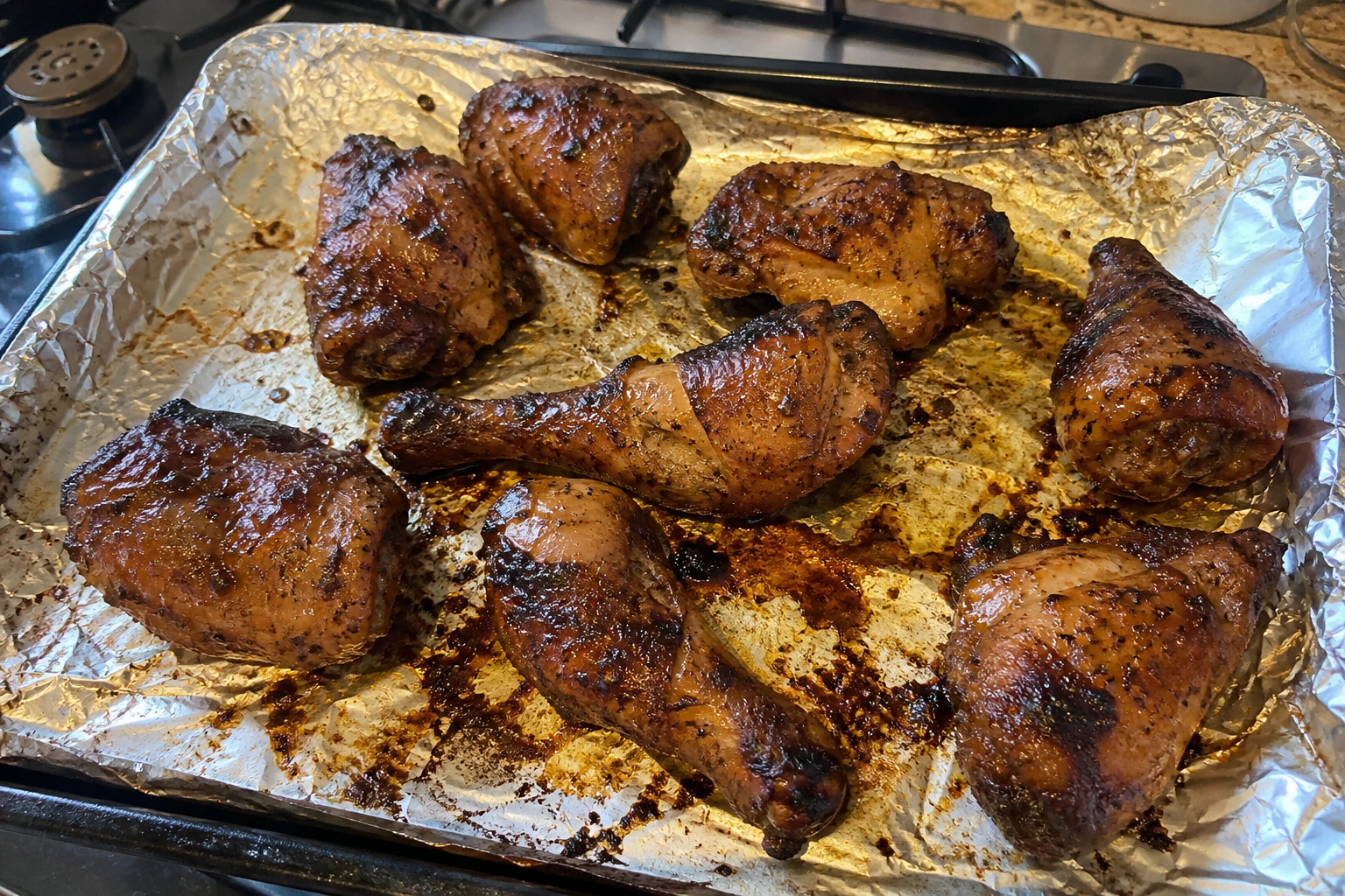 Naturally varied jerk chicken pieces with scattered caramelised spots and only a few dark edge tips